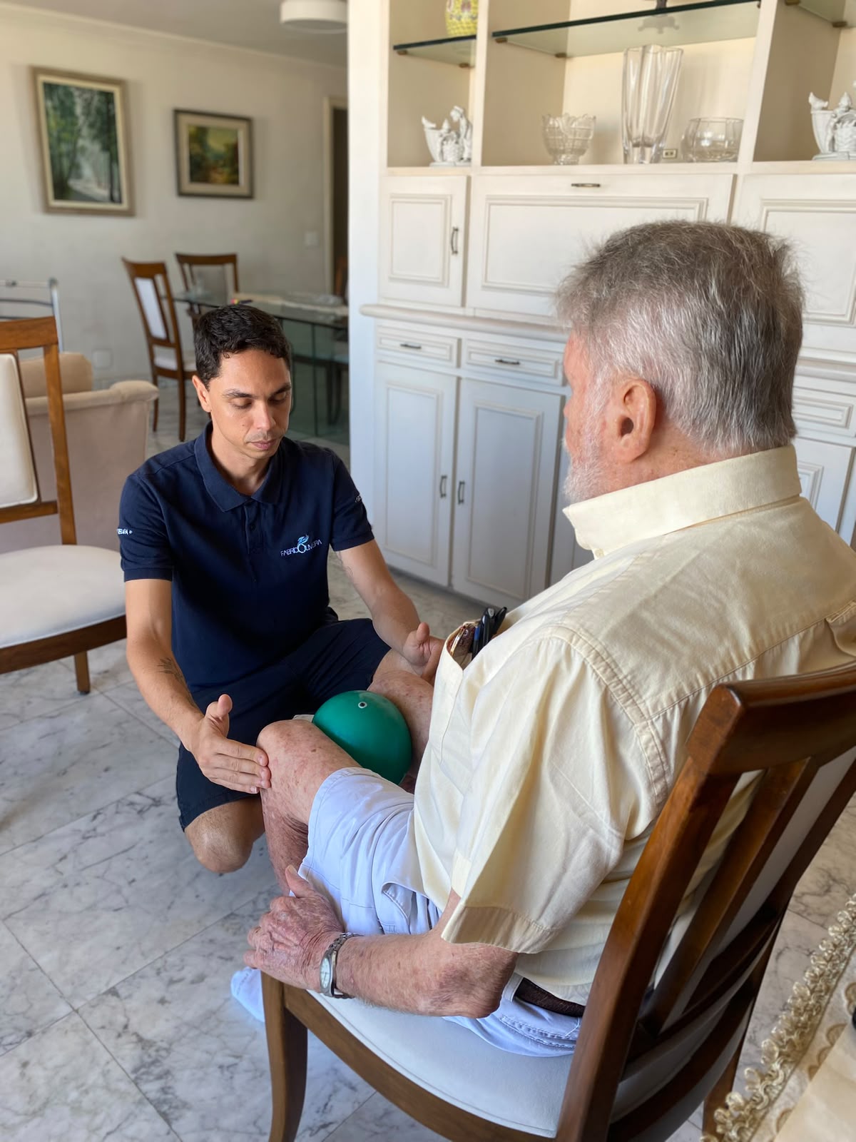 Fisioterapeuta acompanhando paciente idoso durante atendimento domiciliar